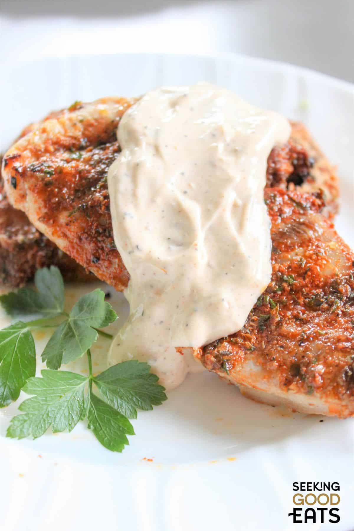 Grilled boneless chicken thighs topped with homemade white BBQ sauce.