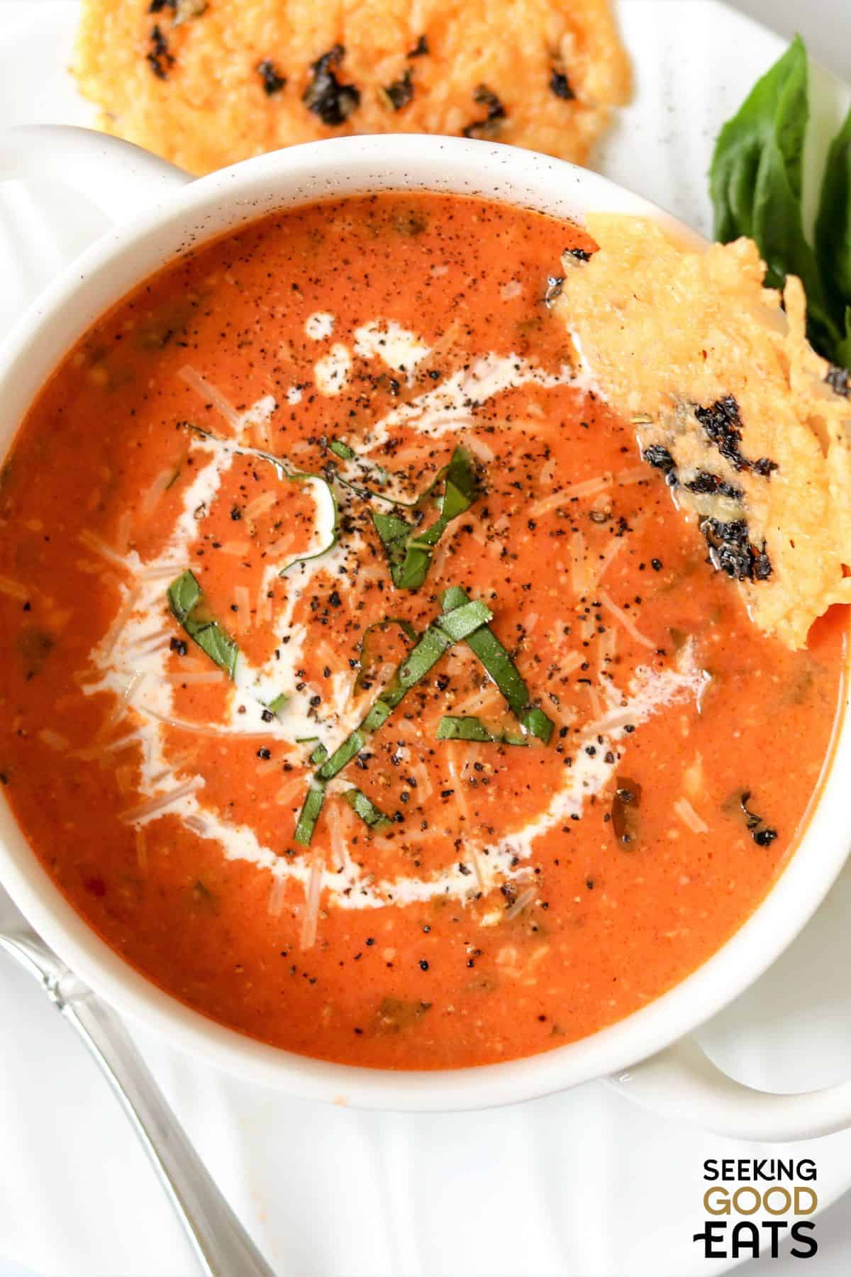 Bowl of tomato and basil soup with parmesan crisps for dipping.