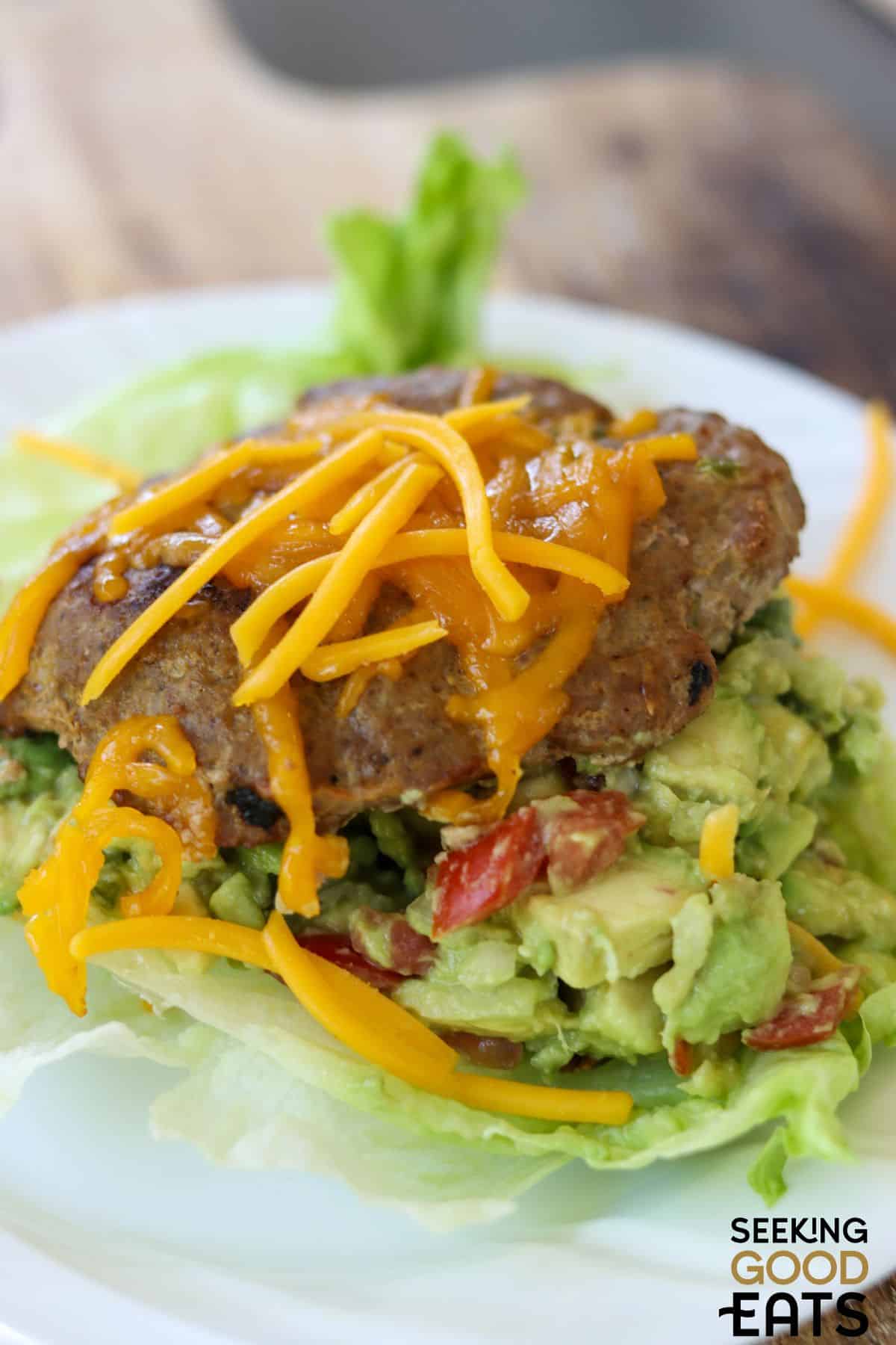 Juicy Southwest turkey burger with cheddar cheese and fresh avocado on a bed of lettuce.