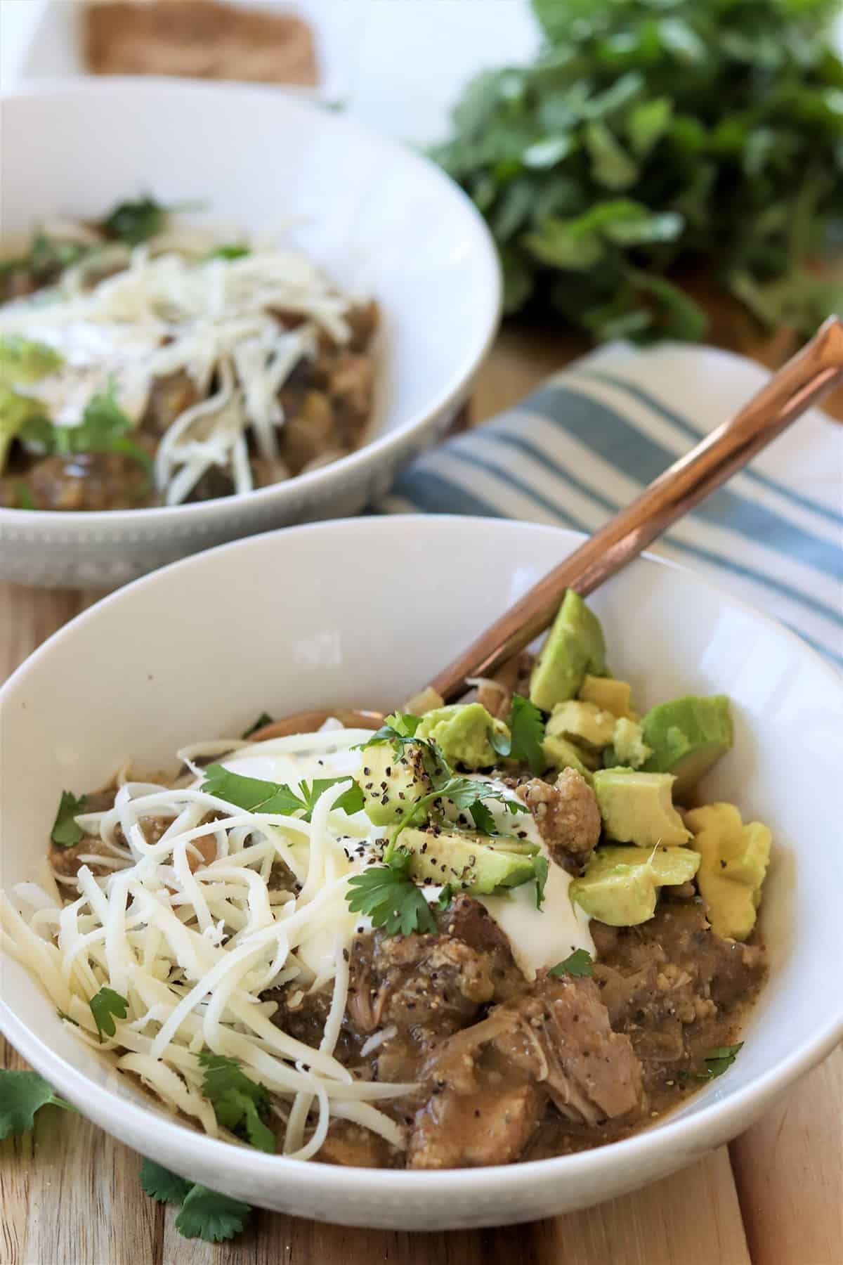 Keto chicken chili without beans topped with avocado sour cream cheese cilantro