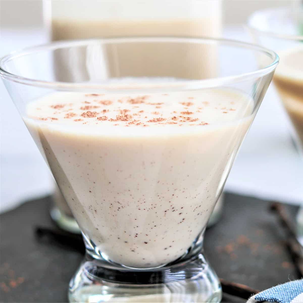Feature image with a closeup image of a glass of homemade irish whiskey recipe garnished with a little nutmeg.