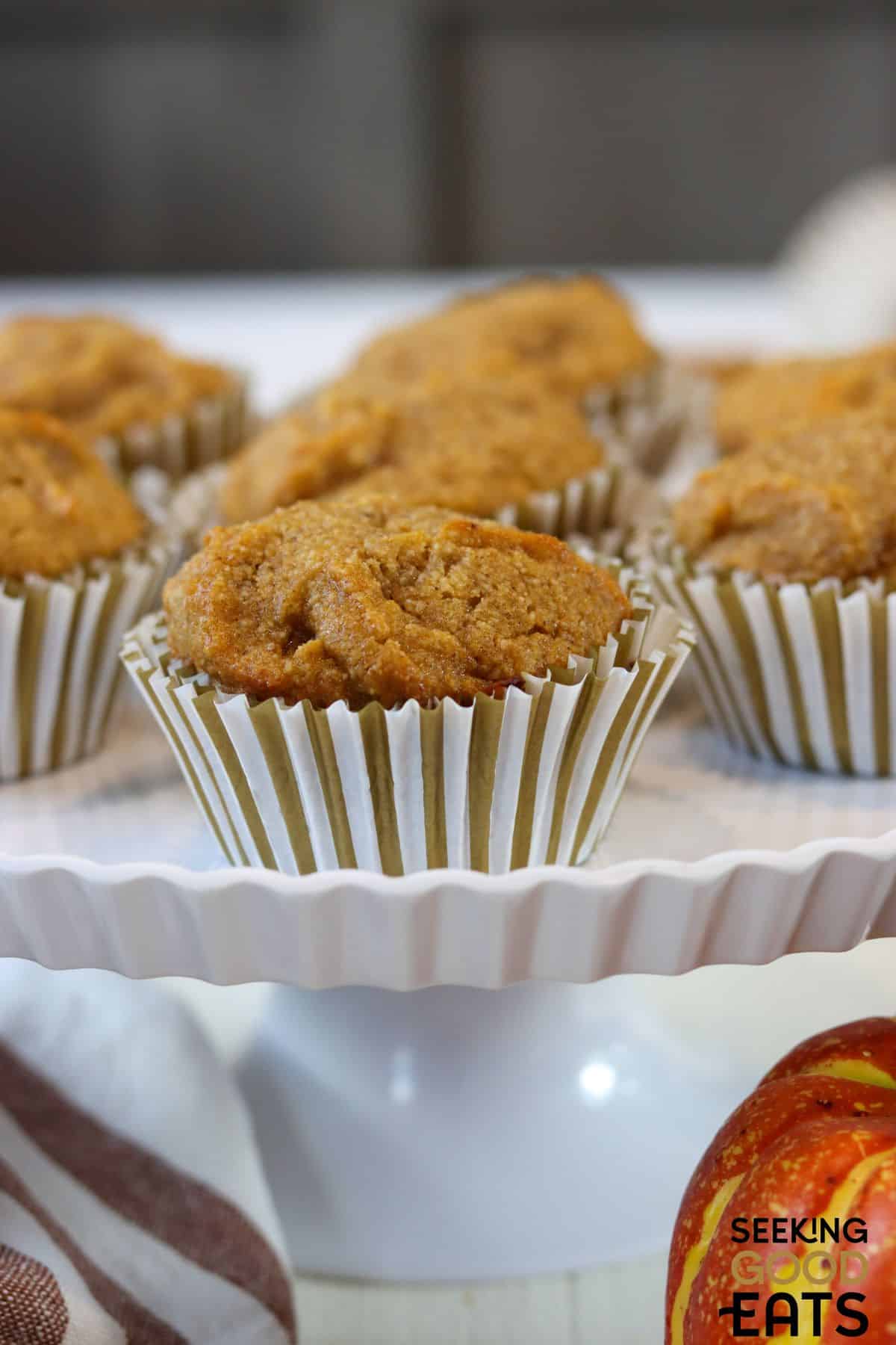 Healthy gluten free pumpkin muffins set out on a cake stand.