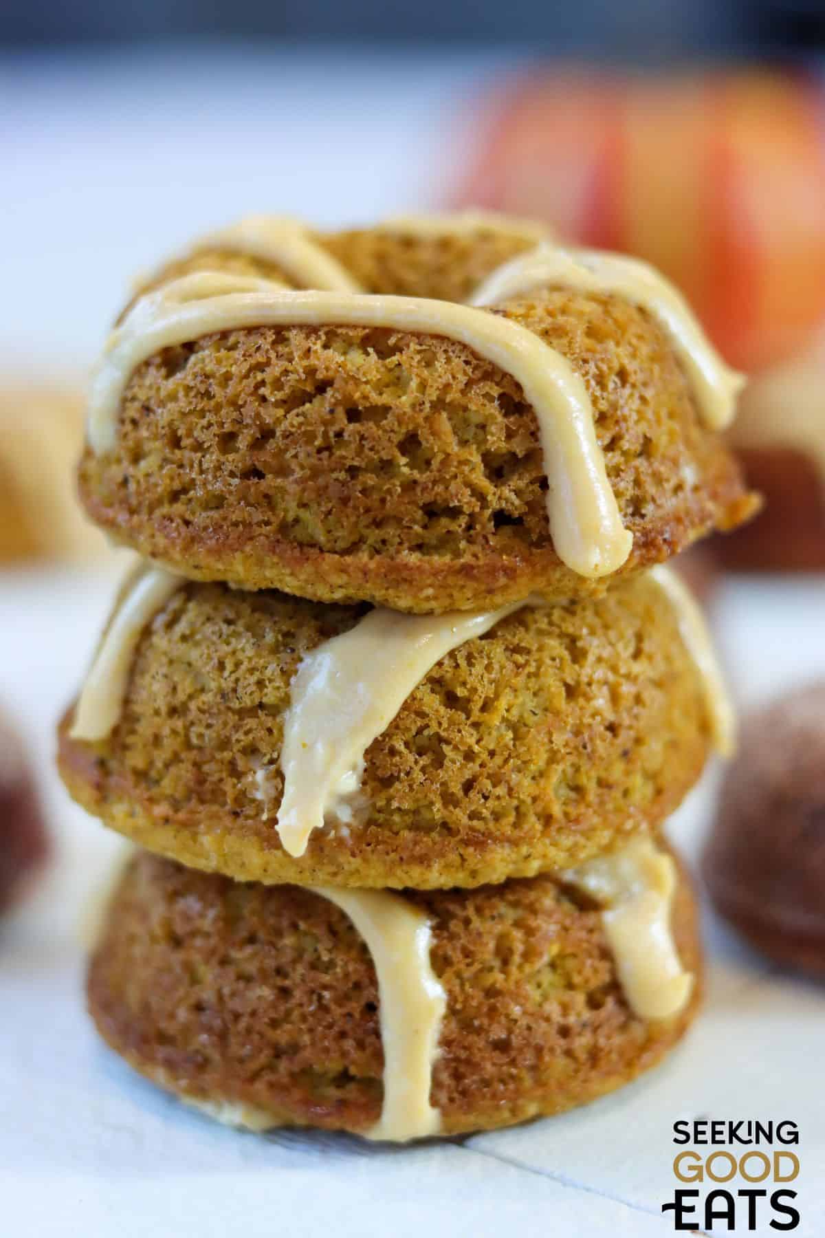 Three pumpkin spice donuts stacked on top of each other.