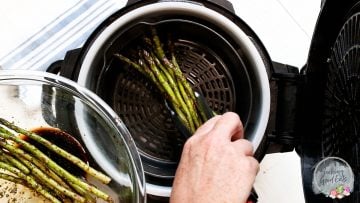 Placing asparagus into an air fryer basket