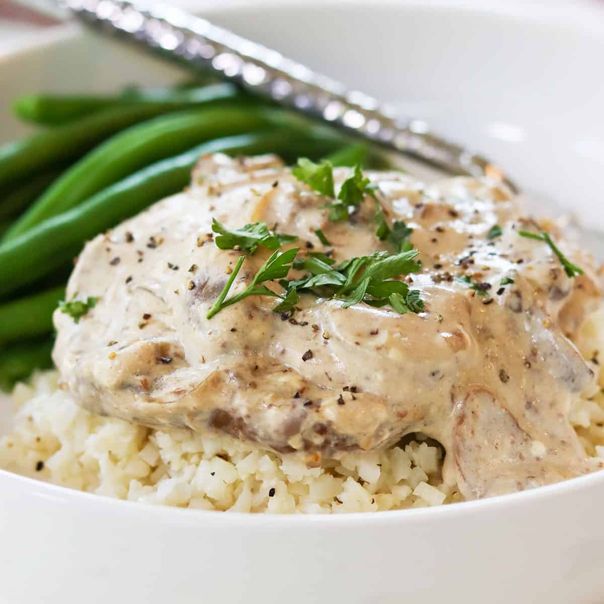Cube steak smothered in gravy and served over riced cauliflower with a side of green beans