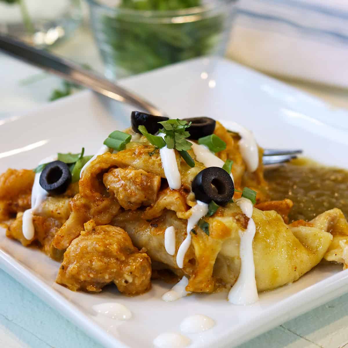 Green enchiladas with chicken have it all - melted cheesy goodness, seasoned tender chicken bites, soft tortillas, slight creamy filling, and some spicy heat that's just right. Green chicken enchiladas can be made a couple of days ahead of time and baked when you're ready. Make these a low carb and keto green chicken enchilada recipe by using a low carb or keto friendly tortilla.