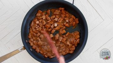 Sauteeing the flank steak in a skillet.