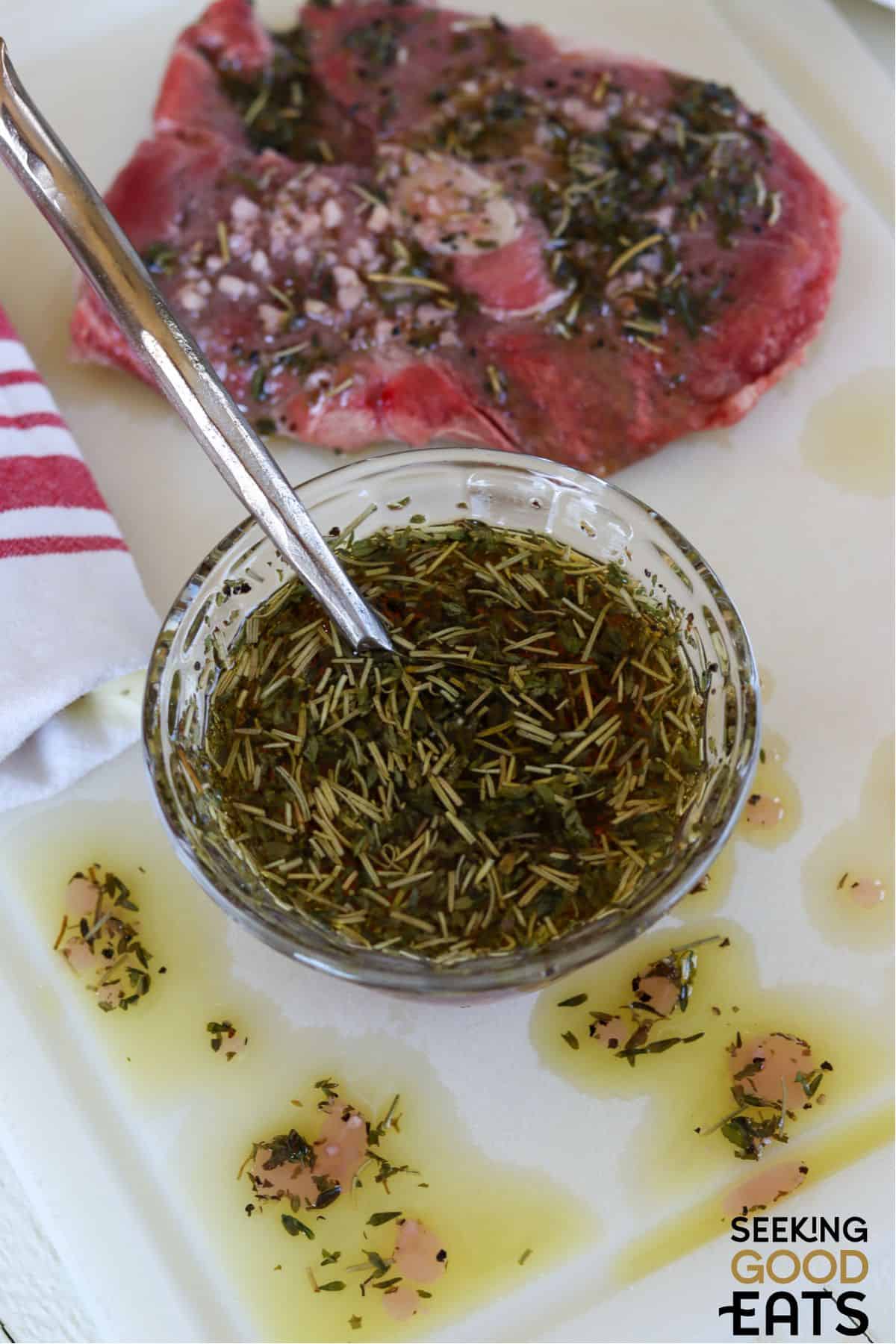 Lamb marinade in a clear bowl with a spoon.
