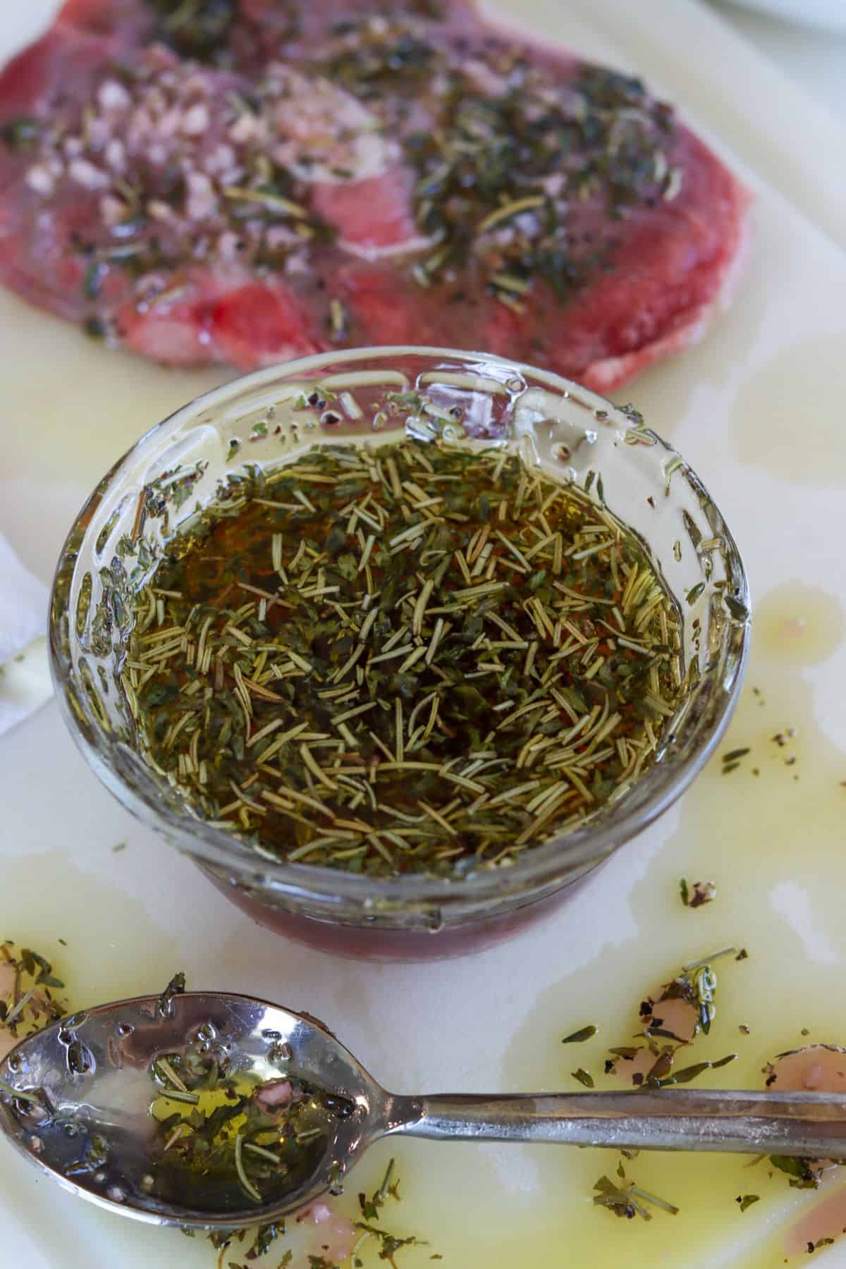 Bowl of lamb marinade with spoon off to the side.
