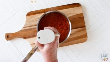 blending the tinga sauce with a handheld blender