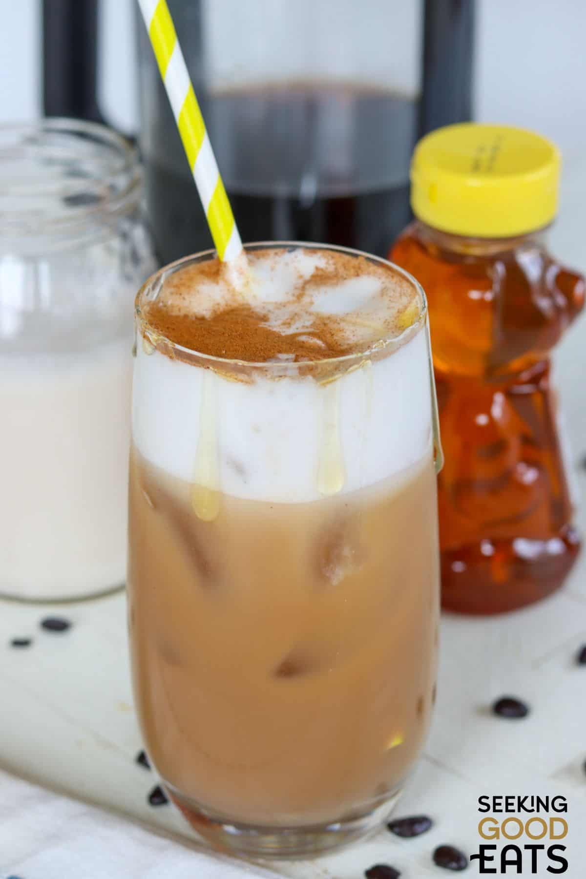 Glass of copycat honey almond milk cold brew served with a straw.
