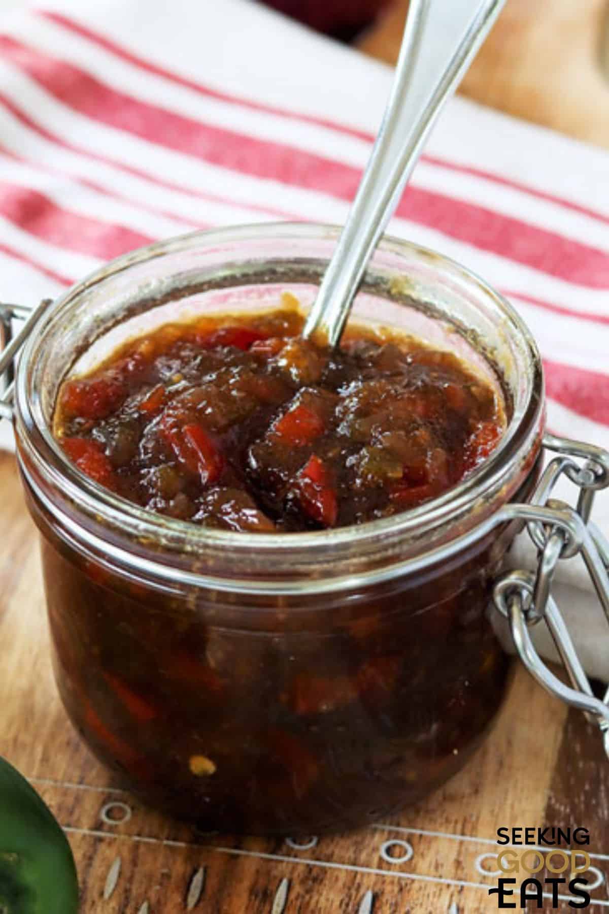 Pepper relish in a jar with a spoon.