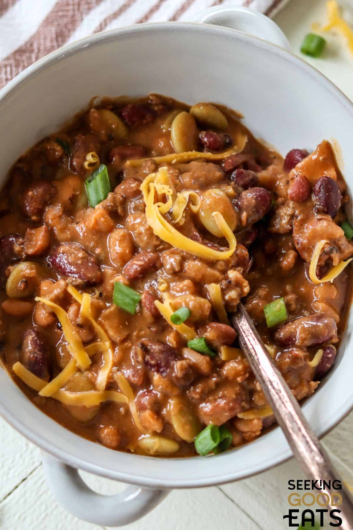 Bowl of hamburger baked beans with spoonful.