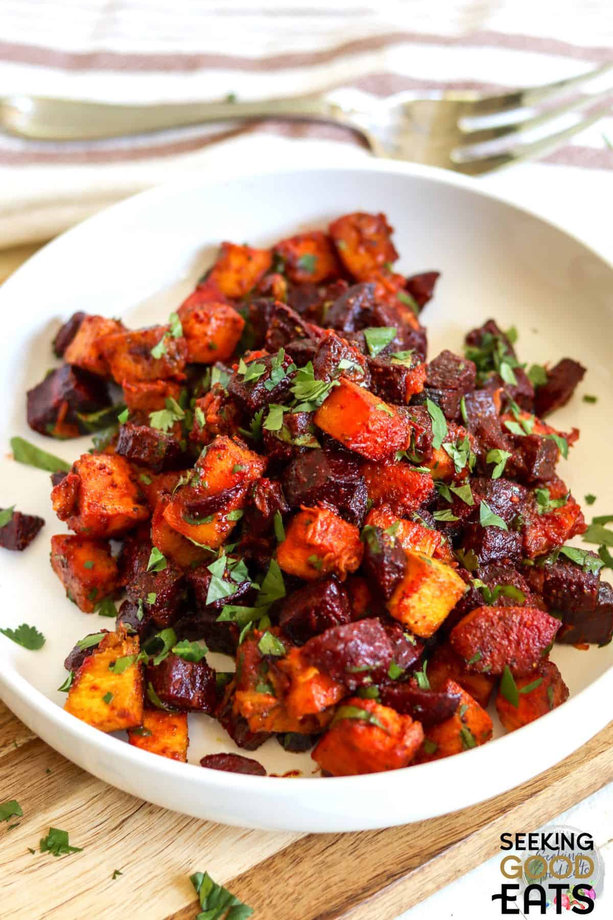Serving of roasted pumpkin and beetroot salad on a white plate.