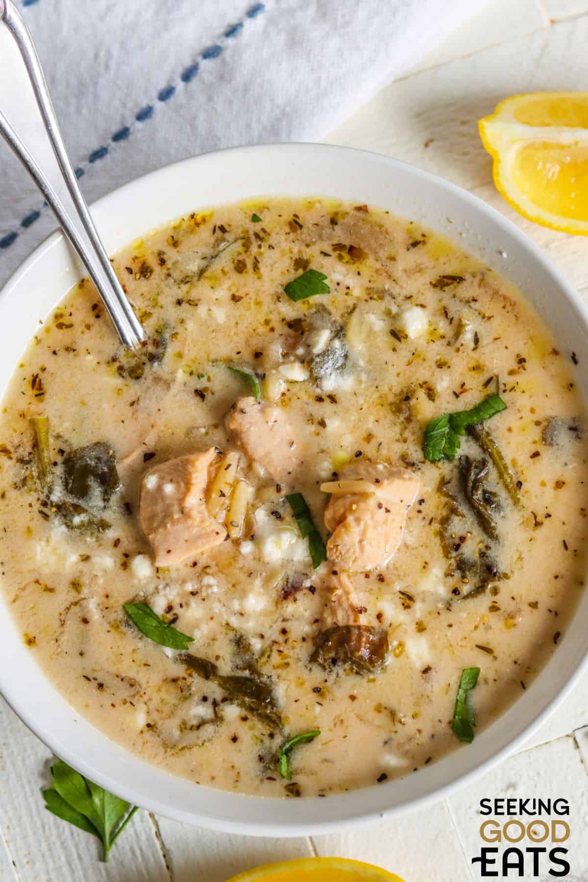 Bowl of creamy Greek lemon chicken soup wit spoon.