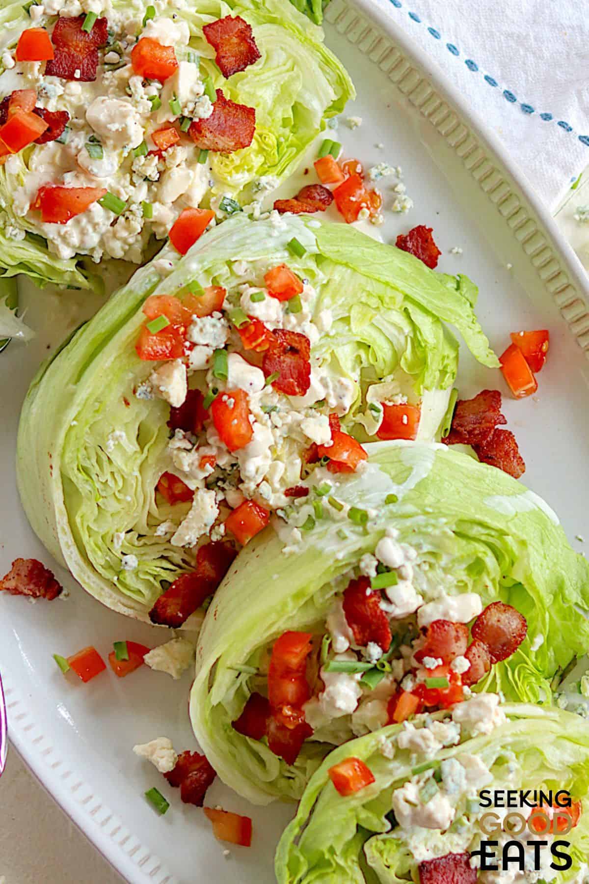 iceberg wedges covered with blue cheese dressing, bacon, and tomatoes