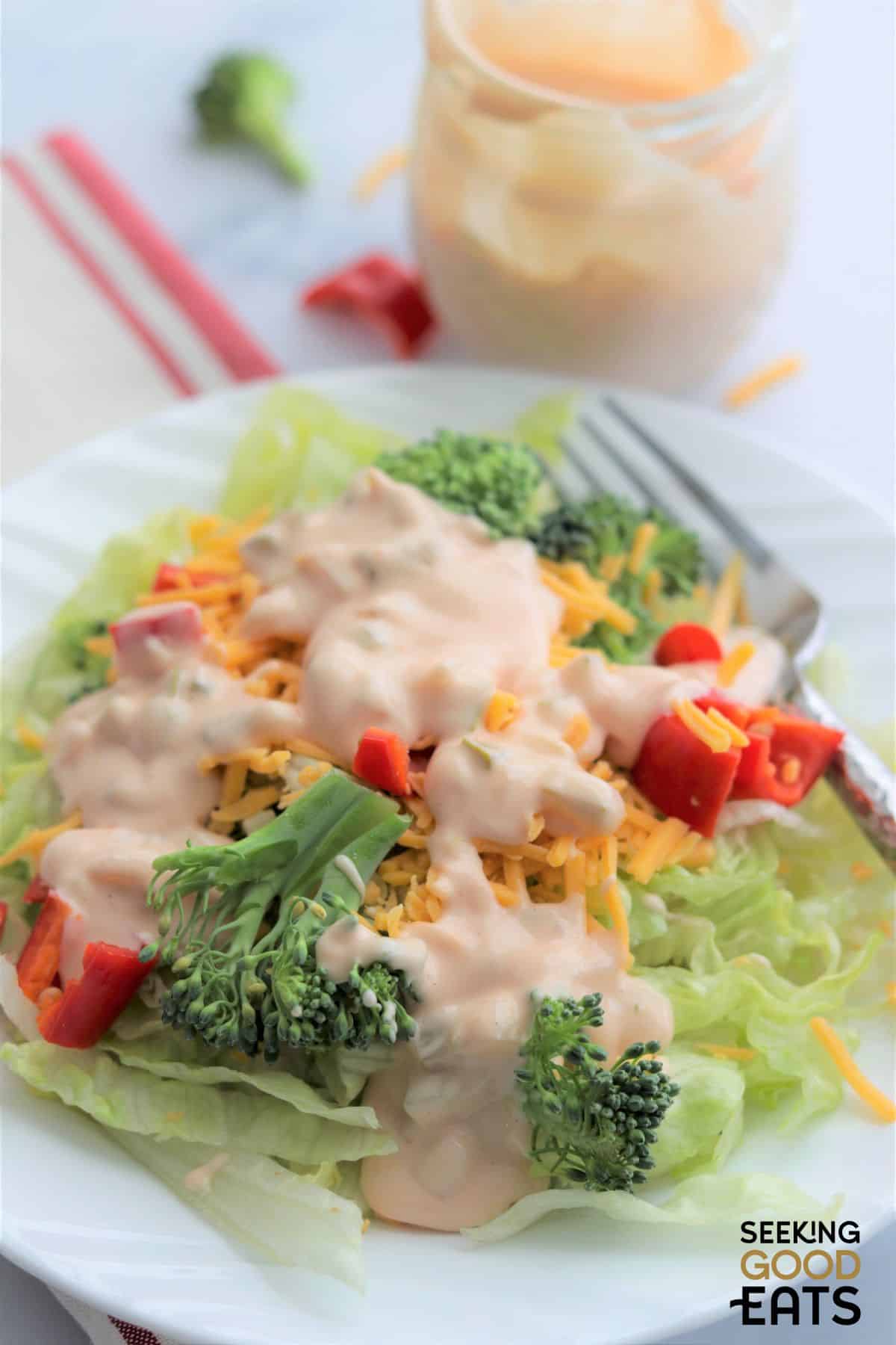 Simple salad with thousand island dressing on top.