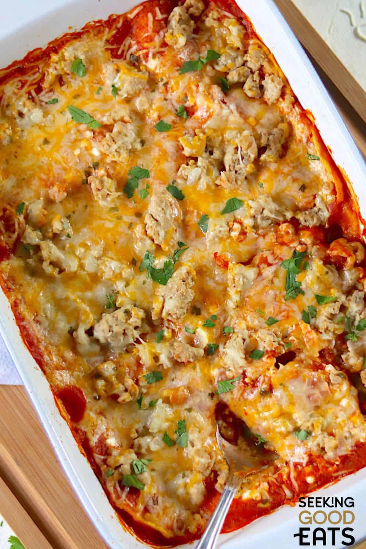Cheesy chicken enchilada casserole in a banking pan.