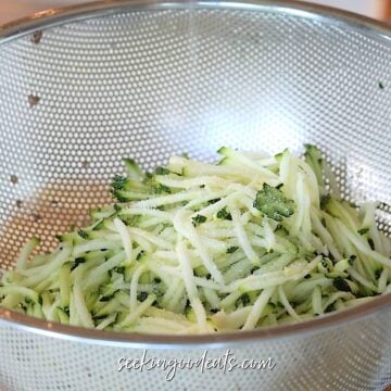 Draining shredded zucchini in a colander.