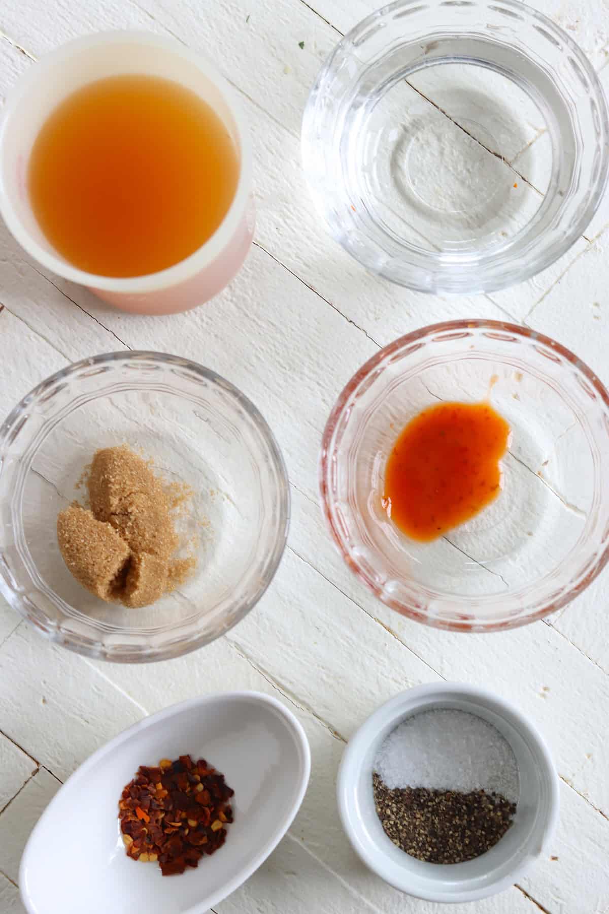 Ingredients needed for making eastern carolina bbq sauce on a white wooden board.