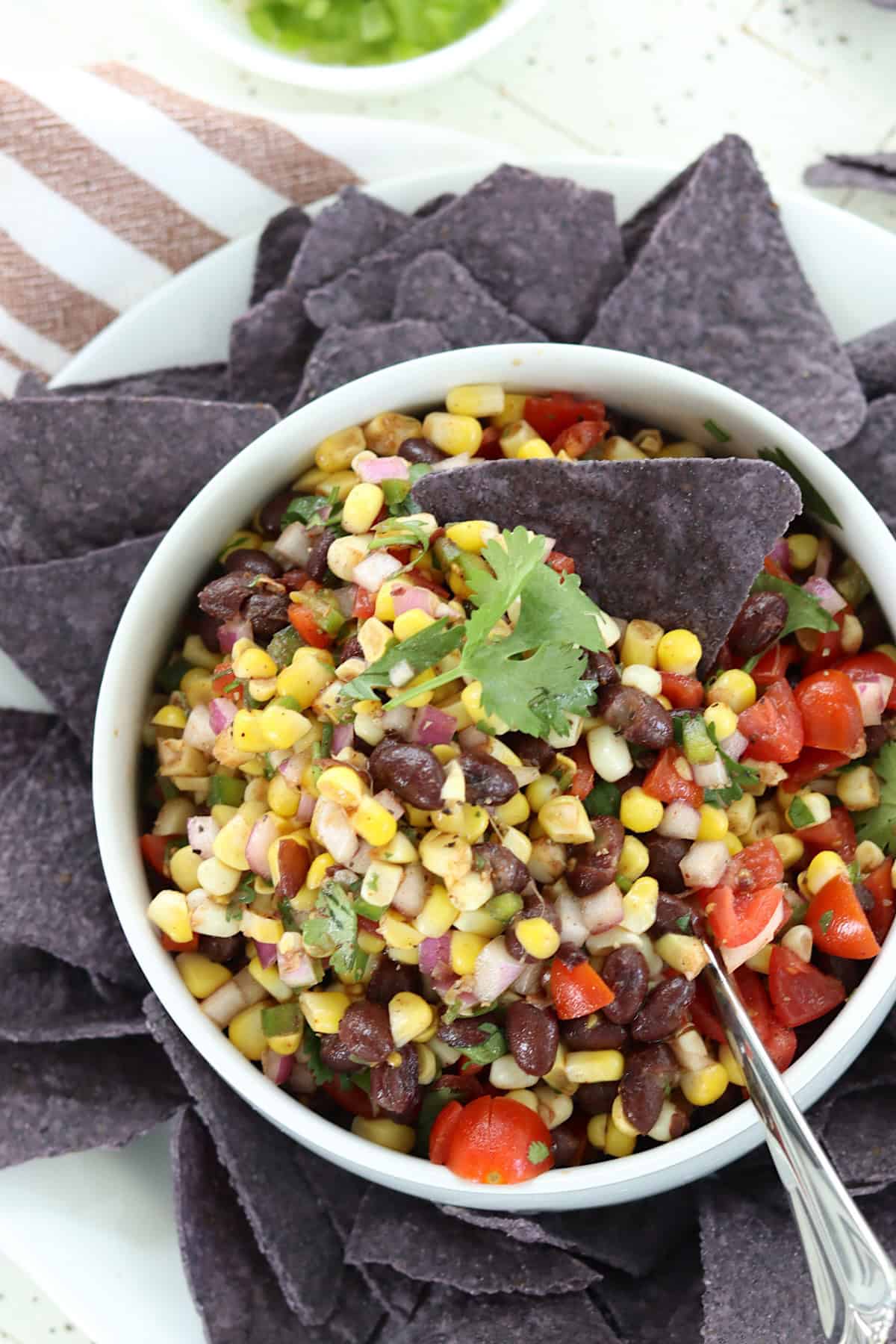 Mexican corn and black bean salsa in a bowl with tortilla chips.