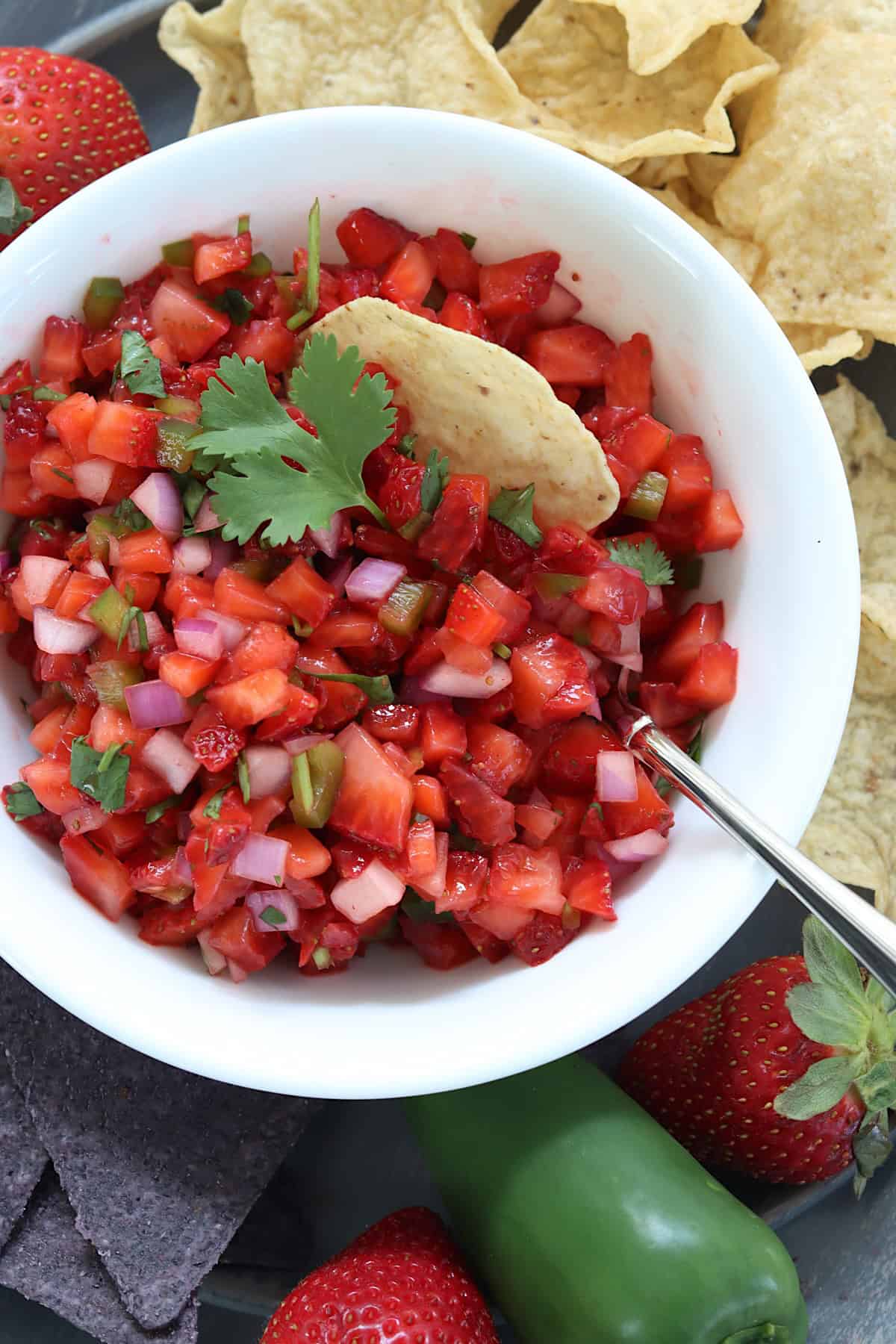 A white bowl of strawberry salsa with jalapeno.