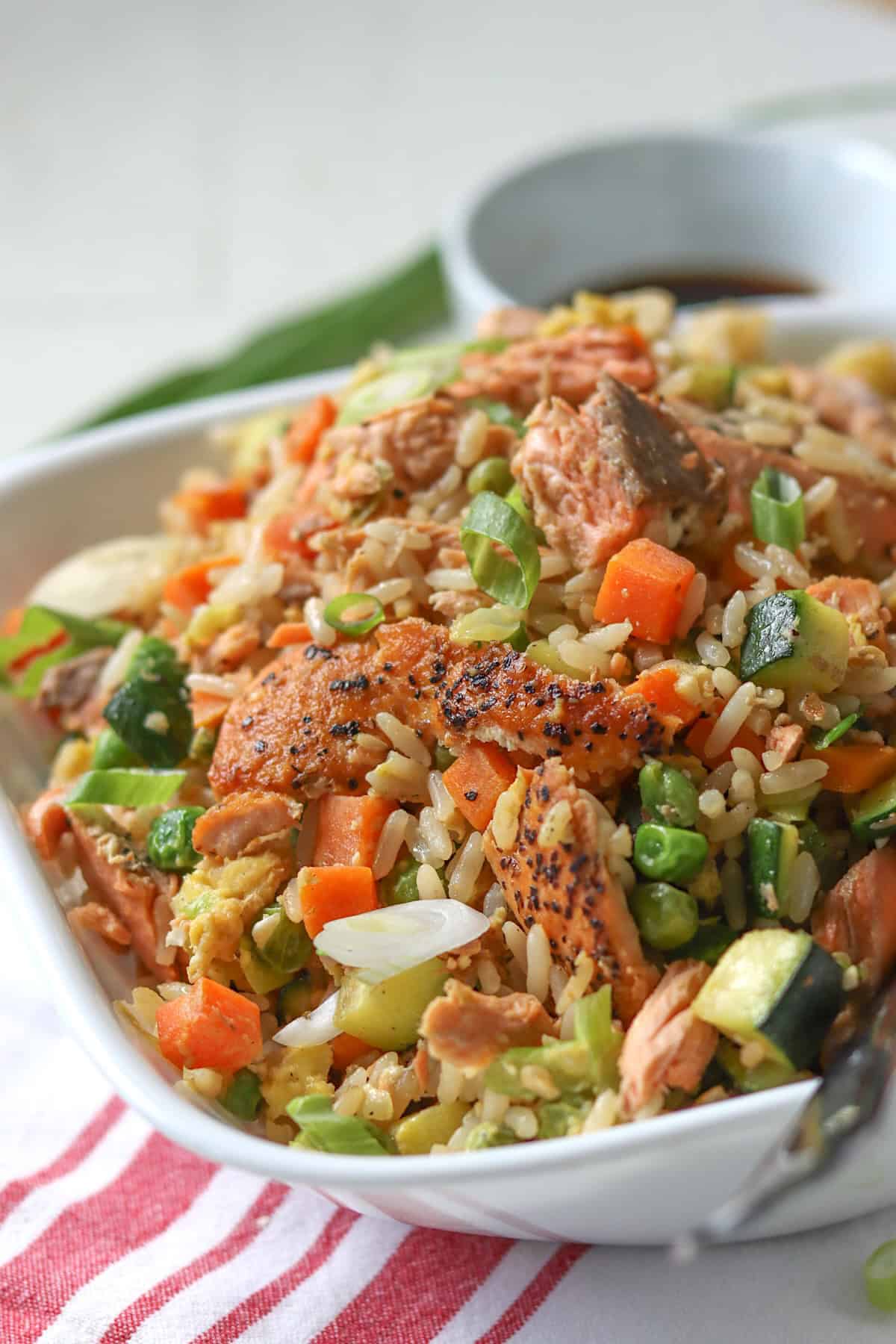 Salmon fried rice in a square white bowl.