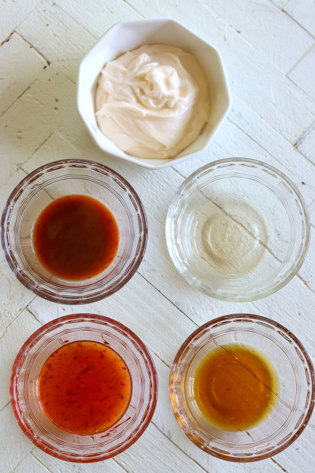bang bang sauce recipe ingredients on a white wooded board.