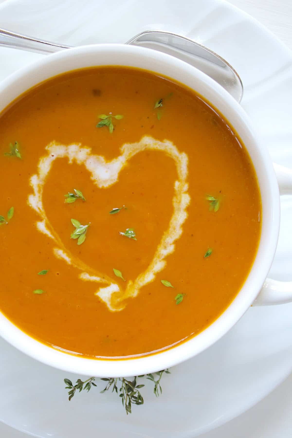 A white bowl of pumpkin soup.