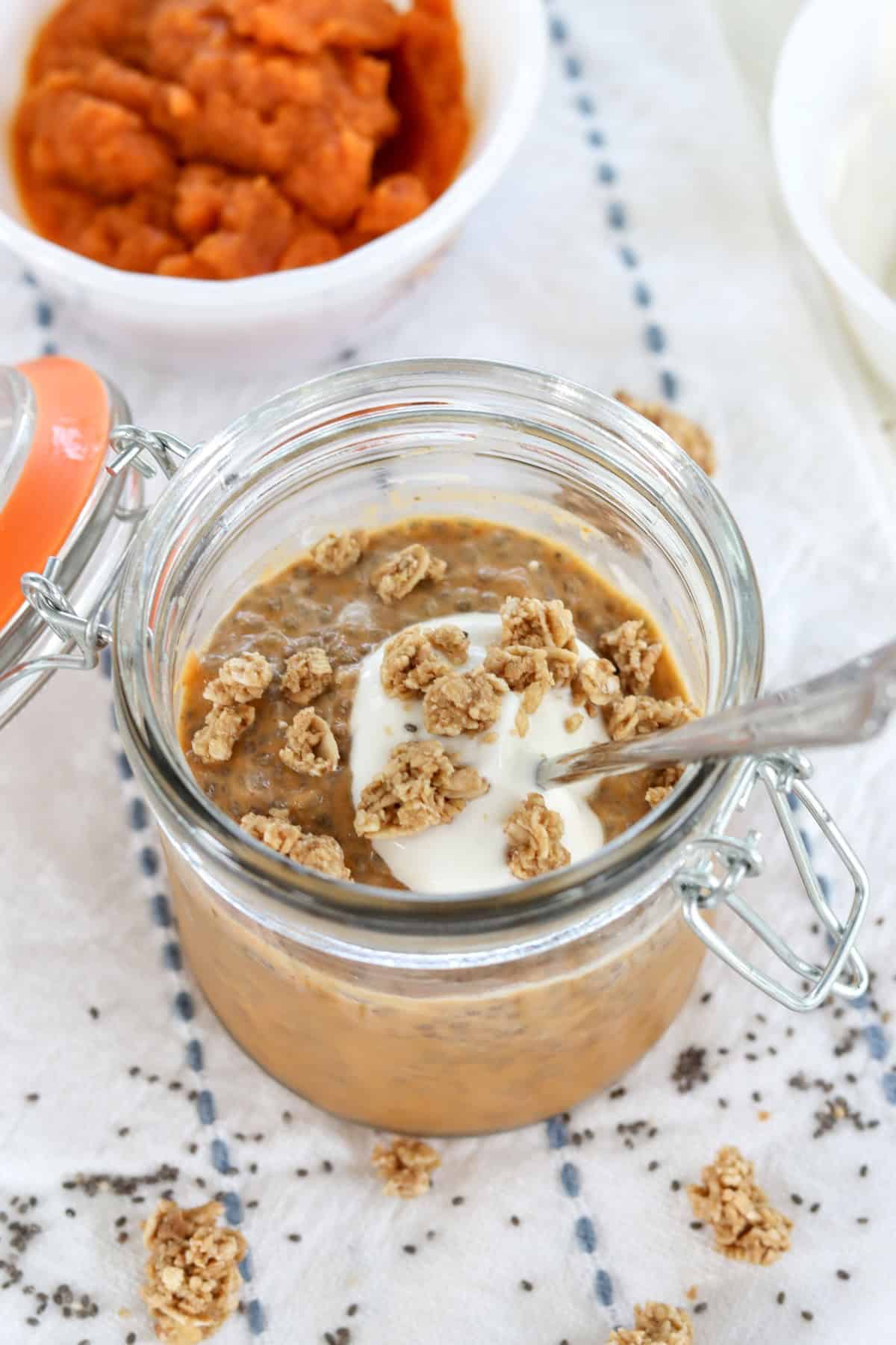 Chia pudding with yogurt and granola in a glass jar.
