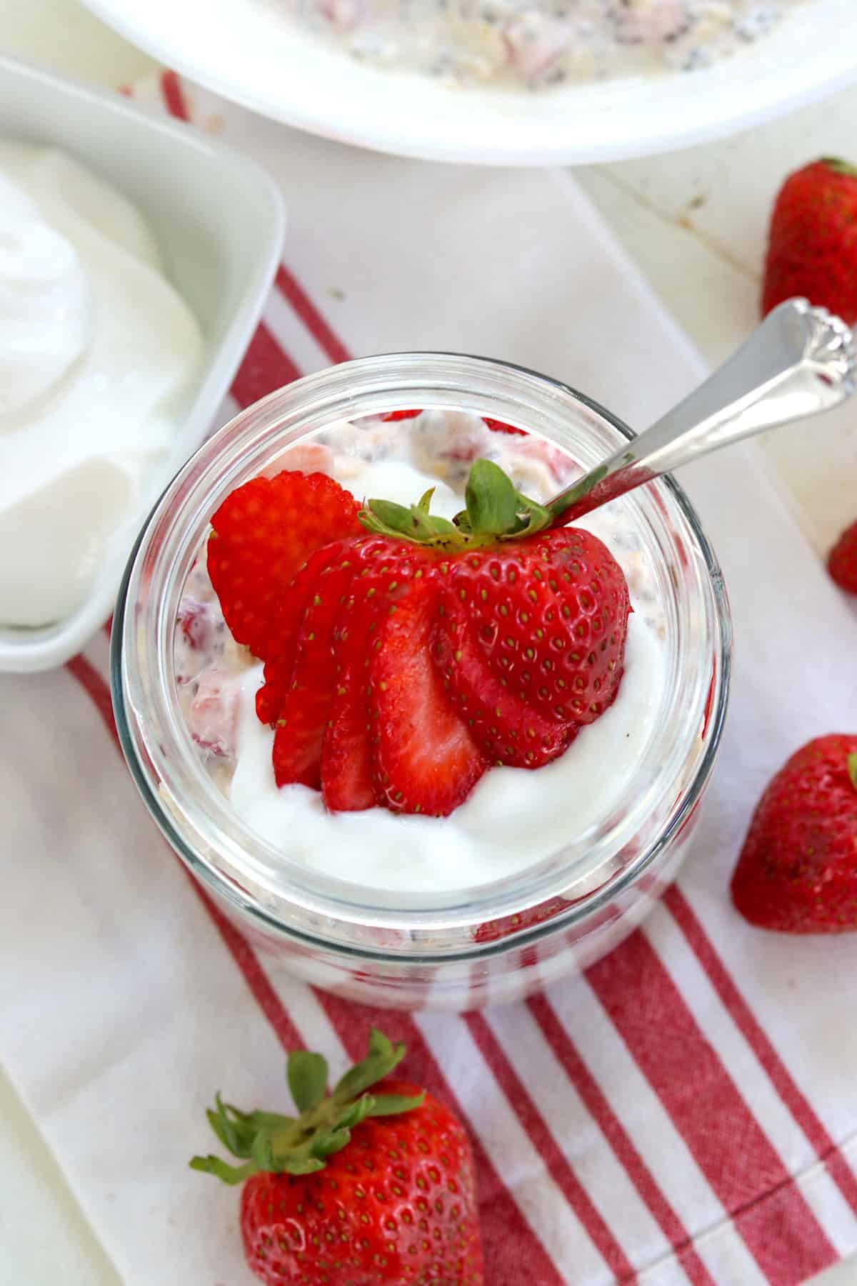 Sliced strawberries garnishing a jar of strawberry overnight oats.