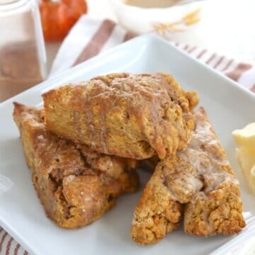 Espresso glazed pumpking scones on a white plate.