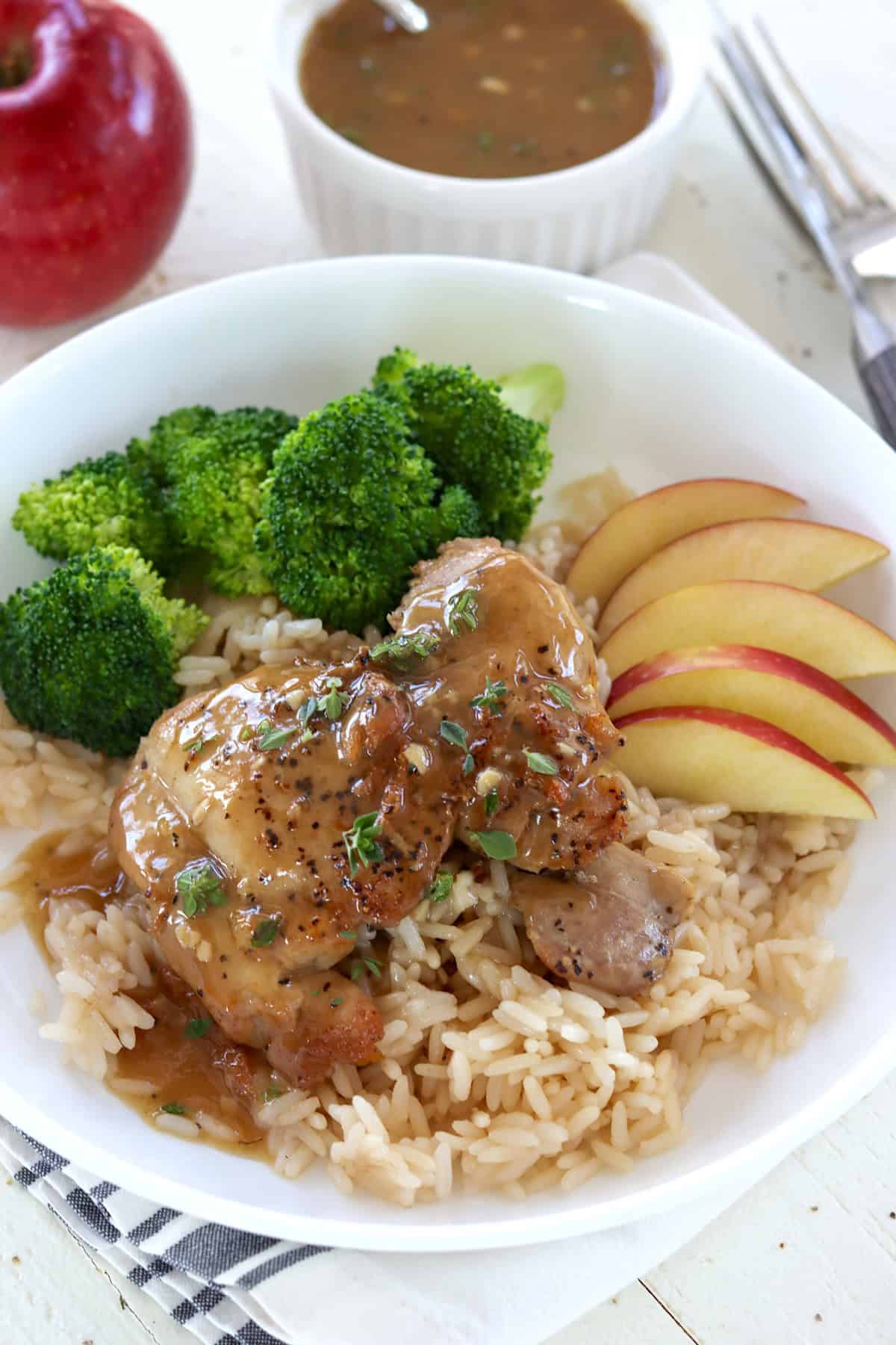 apple cider Glazed chicken thighs in a white bowl.