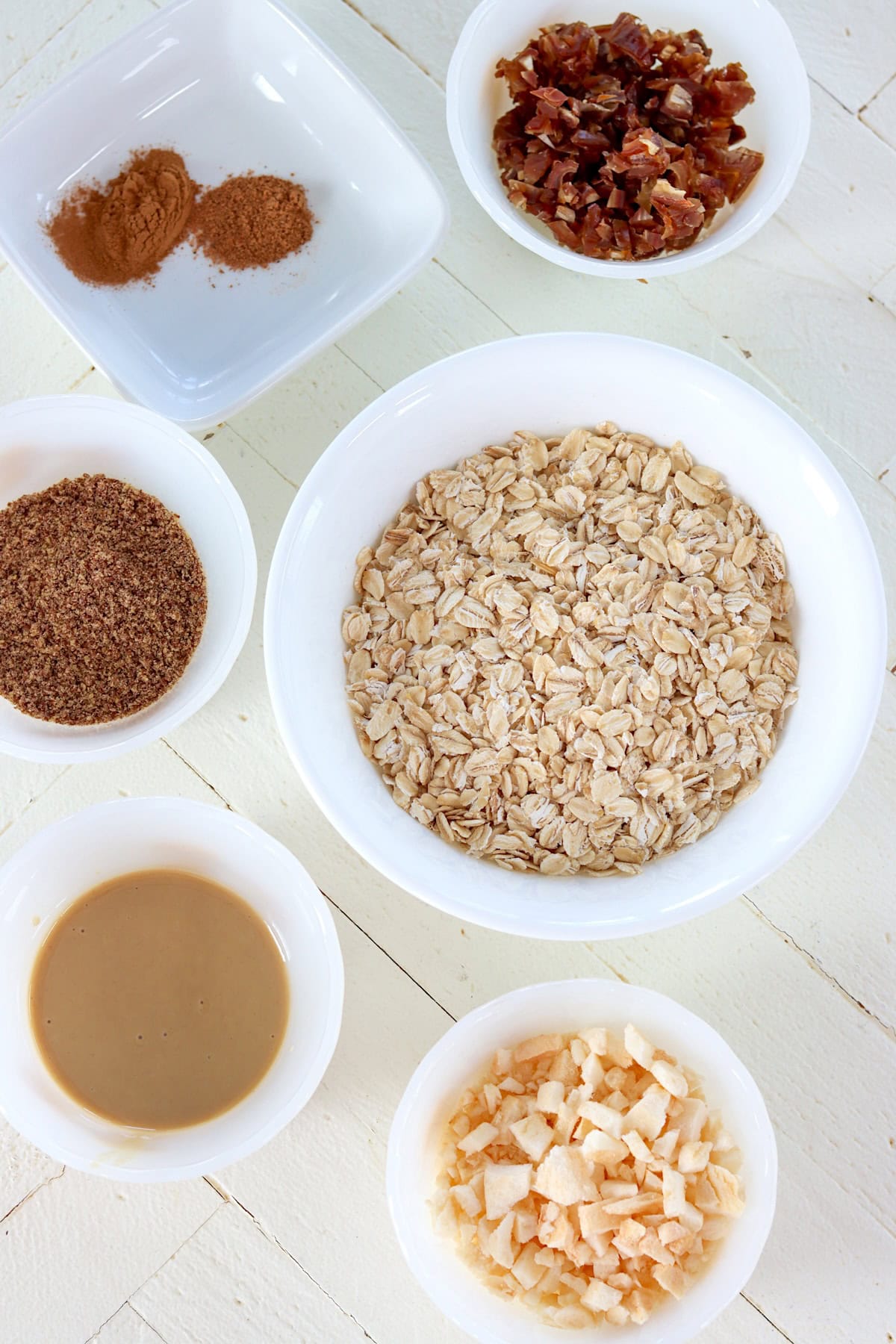 Ingredient needed for making no bake energy bites on a white wooden board.