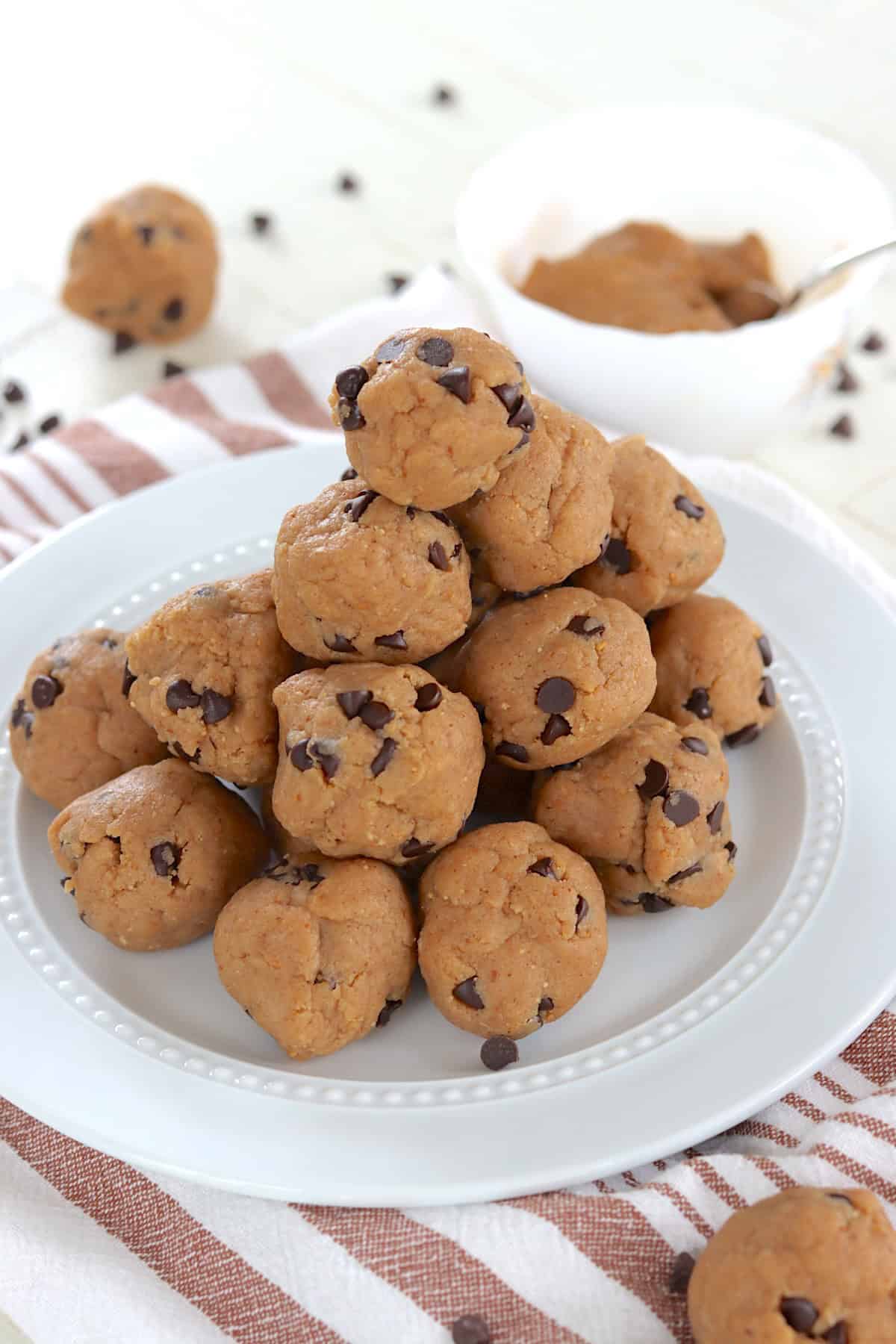 A white plate piled with peanut butter chocolate chip protein balls.