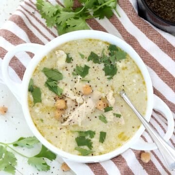 Healthy green chicken enchilada soup in a white bowl with chickpeas and cilantro.