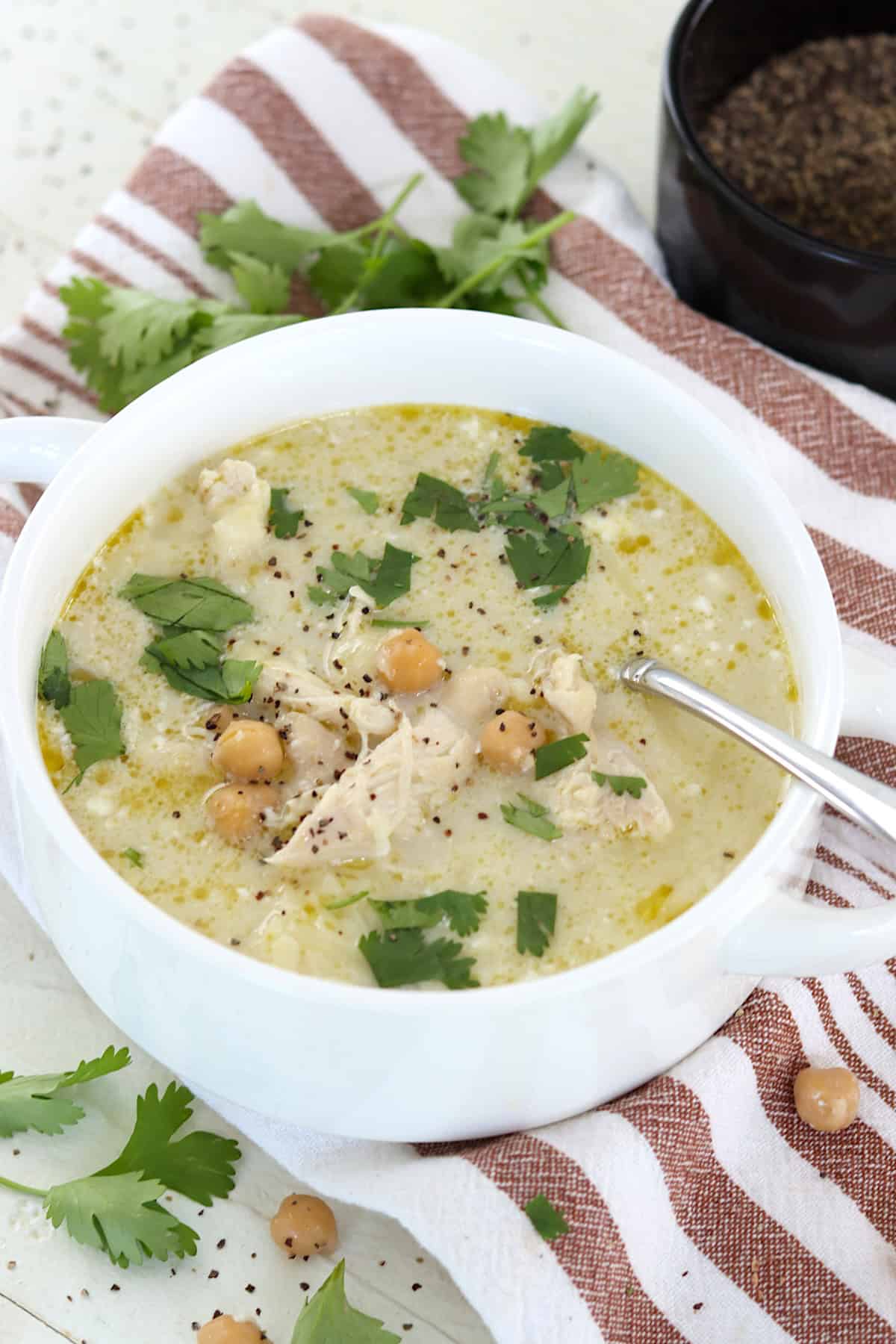 A white handle bowl of healthy green chicken enchilada soup.