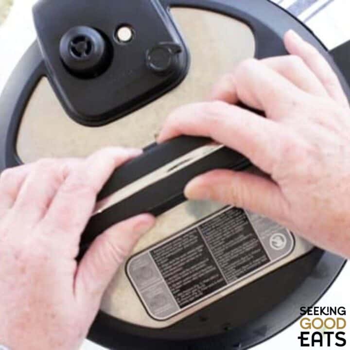 Placing the lid on the Instant Pot chicken soup.