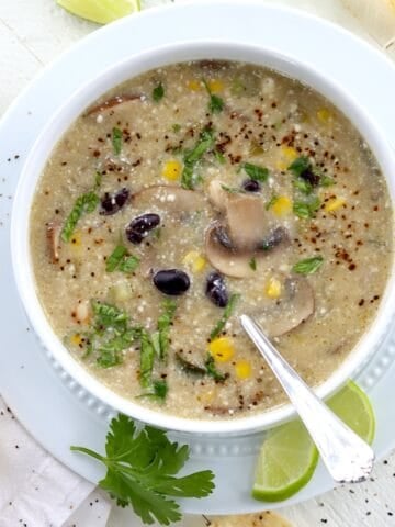A white bowl of white bean green enchilada soup