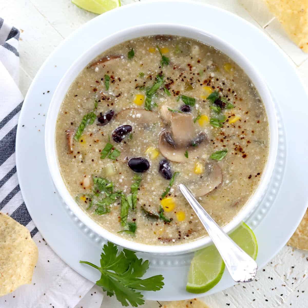 A white bowl of white bean green enchilada soup