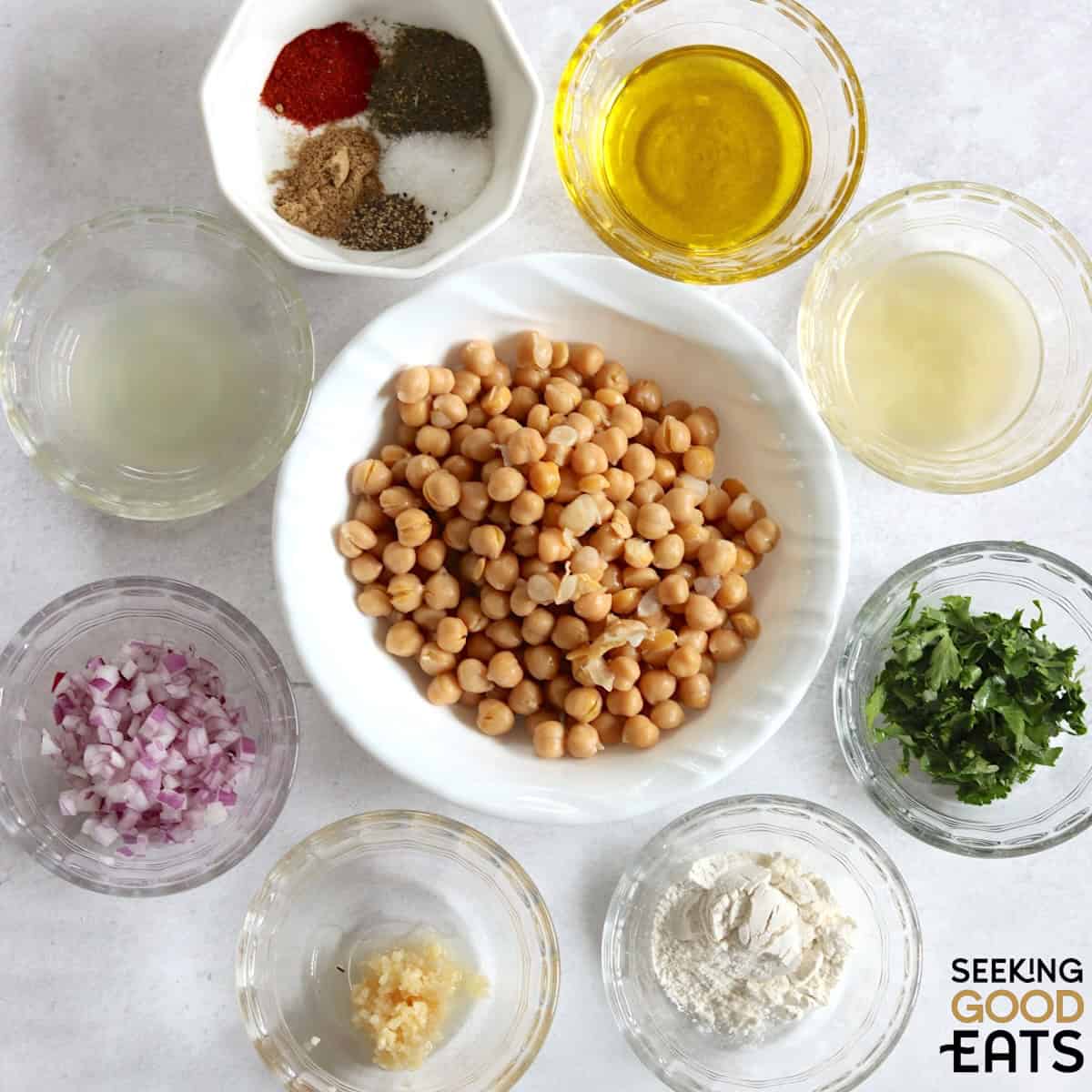 Ingredients needed to make vegan chickpea fritters on a marble countertop.