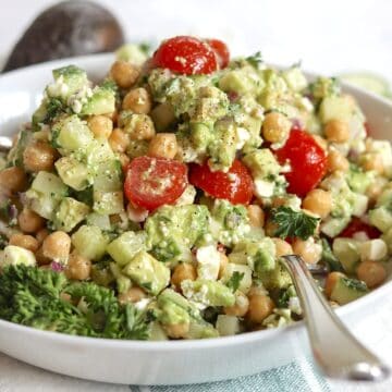 Feta avocado chickpea salad in a white serving bowl.