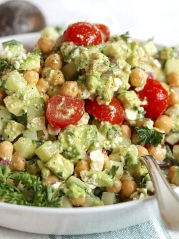 Feta avocado chickpea salad in a white serving bowl.