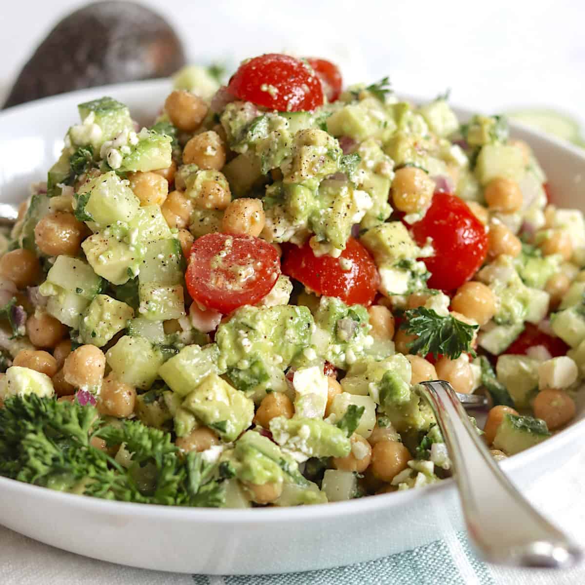 Feta avocado chickpea salad in a white serving bowl.