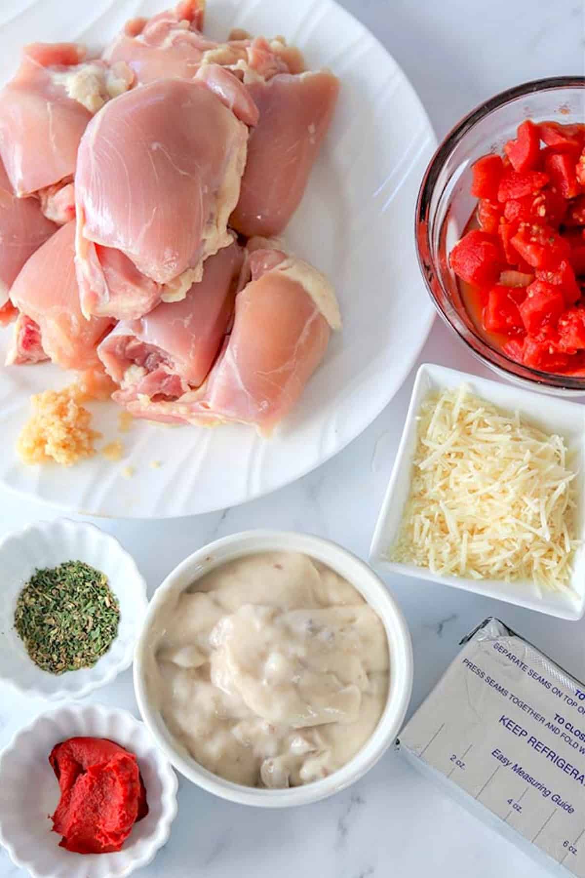 italian slow cooker chicken thighs ingredients on a white board.