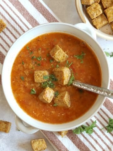 Red lentil tomato soup in a white bowl.