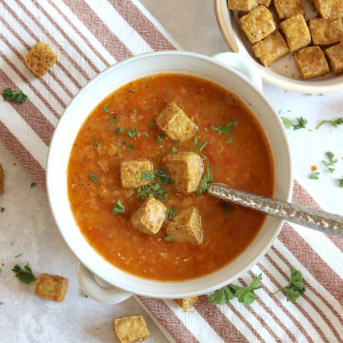 Red lentil tomato soup in a white bowl.