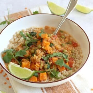 Sweet potato red lentil curry recipe in a white serving bowl and silver spoon.