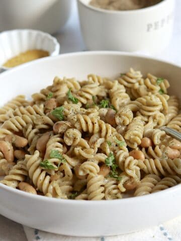 High protein rotini vegan pesto pasta with white beans and fresh parsley.