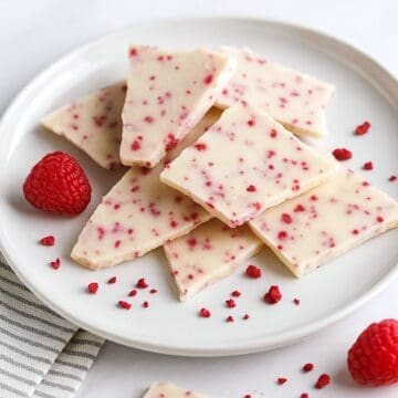 Close-up of raspberry white chocolate bark with raspberry flecks on marble.